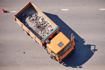 Truck body with crushed asphalt fragments during road repair, top view