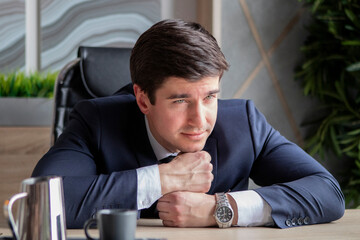 Obraz premium portrait of young businessman in a dark blue suit working in the office