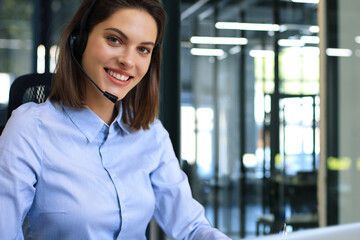 Portrait of happy smiling cheerful support phone operator in headset at office.