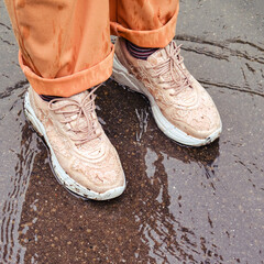 Legs of man standing in the rain in bad autumn weather