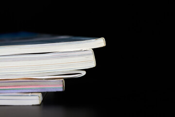 A part of a stack of magazines on dark background