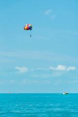 Rainbow parachute on the background of the blue sea and sky. Landscape. Summer. Vacation.