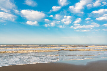 Wavy sea and blue sky with clouds