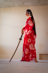 Fototapeta na wymiar Young beautiful asian woman in the kimono and katana sword.