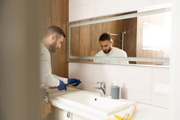 a worker installs a wash basin in a bathroom.