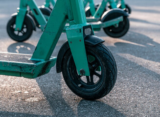 Green color electric scooters outdoors at sunny day.