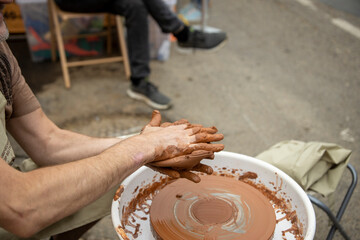 A potter makes a pot on a circle. The hands of the master create from clay. Man making ceramic pot.