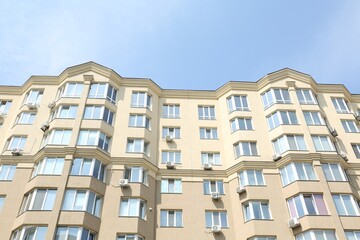 Fototapeta na wymiar Exterior of multi storey apartment building against blue sky, low angle view