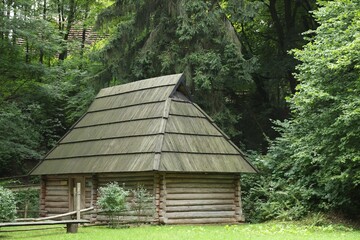 Old wooden hut in forest on summer day