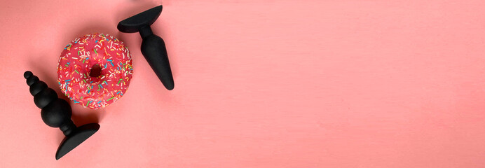 Banner. Sex toys and donut. Black butt plugs on pink background - obrazy, fototapety, plakaty