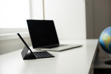 laptop and tablet on a white table