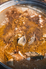 Beautiful surface of fish soup boiled over a fire with spices. Background of food close-up from above.