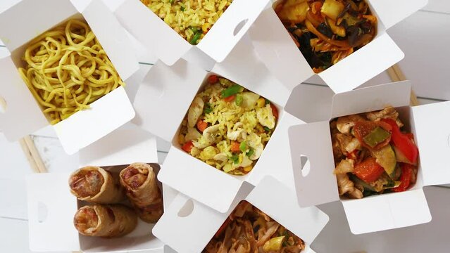 Take away food concept. Spring rolls, fried rice with chicken, curry and wok noodles