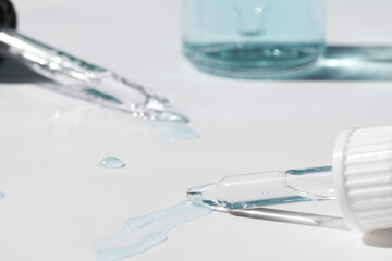 Pipette with fluid serum, oil, face gel cleaner. Cosmetics and healthcare concept closeup. Dose of retinol with air bubbles. Flat lay. Monkeypox, coronavirus research