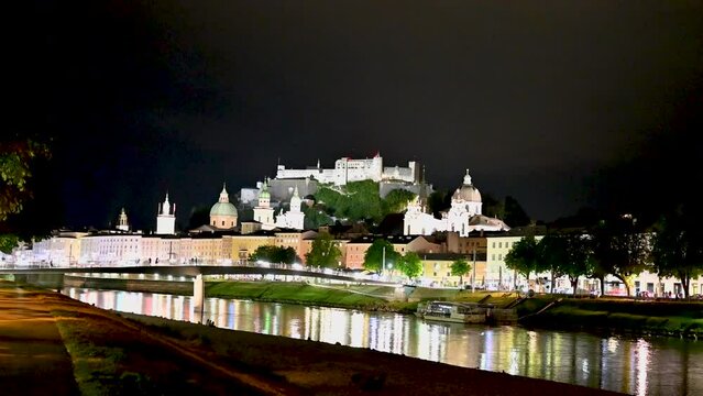 Salzburg, Austria, August 2022. Fascinating night view of the old town. A storm is coming and several lightning bolts illuminate the sky in blue. The fort at the top of the hill stands out.