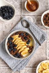 Useful breakfast. Healthy food concept. Greek yogurt with chocolate granola, banana, blueberries and honey. Top view.