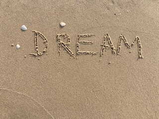 on the beach is carved with letters in the smooth sand the writing Dream