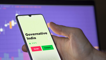 Un inversor está analizando el governative india etf fondo en pantalla. Un teléfono muestra los precios del ETF para invertir, texto en español.