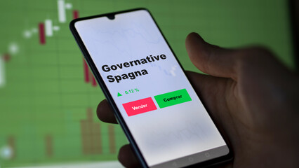 Un inversor está analizando el governative spagna etf fondo en pantalla. Un teléfono muestra los precios del ETF para invertir, texto en español.
