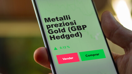 Un inversor está analizando el metalli preziosi gold (gbp hedged) etf fondo en pantalla. Un teléfono muestra los precios del ETF para invertir. Texto en español.