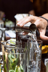 Bartender serving alcohol in a cocktail. Cocktail preparation in a night environment. It can be a hotel, a restaurant or a night club.