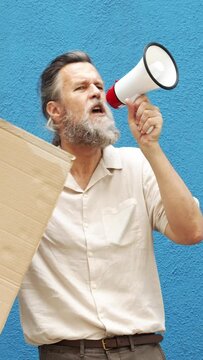 Vertical video.Detail of a middle-aged man with a megaphone in a protest against climate change 