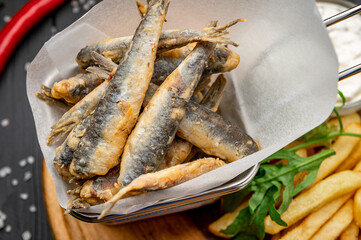 Small fried fish and french fries at an seaside restaurant. Fried anchovies