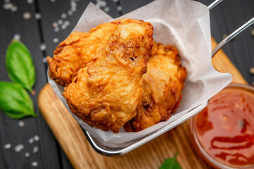 Fried chicken wings in batter with hot sauce