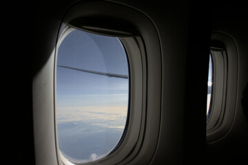 View through two windows of a plane on a sunny sky.