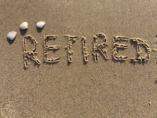 on the beach is carved with letters in the smooth sand the writing Retired