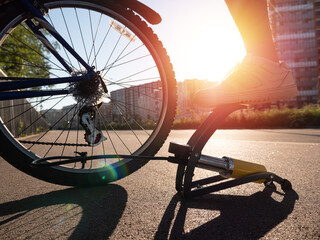 Naklejka na ściany i meble Man inflating bike tire outdoors. Pumping up bicycle tyre