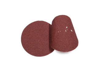 Two pieces of round red sandpaper. One was used and the other was not.