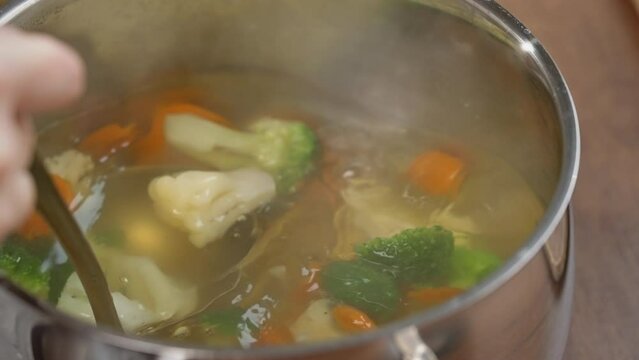 b roll shot lunch at home open pot lid vegetable soup with carrot and broccoli healthy vegetarian as a main dish