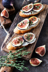 Breakfast with figs, cream cheese and honey toasts on a wooden board
