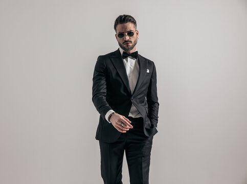 handsome elegant man with hand in pocket wearing black tux