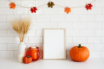 Picture frame mockup in cozy home interior with fall decor, vase of dried wheat, candle, pumpkin....