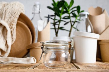 Glass jar for food storage on the background of eco-friendly paper and glassware. The concept of freedom from plastic and zero waste.