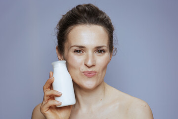 happy modern 40 years old woman with cosmetic cream jar