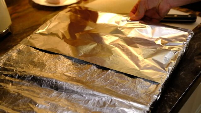 Cubed potatoes on a baking sheet covered with aluminum foil ready to go into the oven.