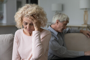 Offended senior wife feeling bad, upset after conflict, row, arguing with husband, touching head,...