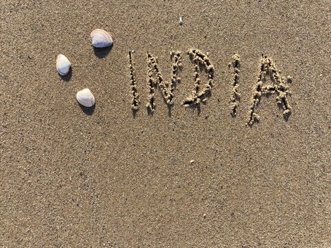 on the beach is carved with letters in the smooth sand the writing India