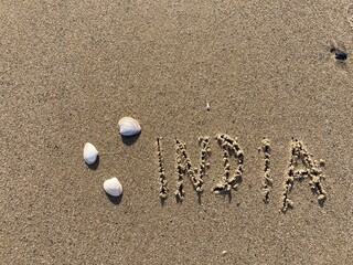 on the beach is carved with letters in the smooth sand the writing India