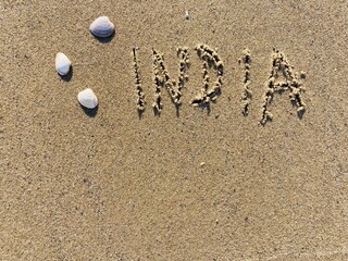 on the beach is carved with letters in the smooth sand the writing India