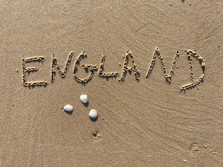 on the beach is carved with letters in the smooth sand the writing England