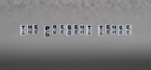 the present tense word or concept represented by black and white letter cubes on a grey horizon...