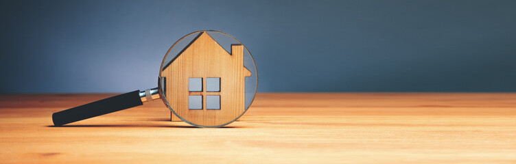 Wooden house and magnifying glass