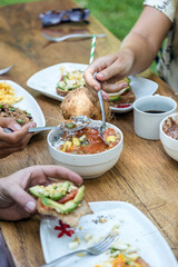 Friends having a vegetarian breakfast with toast, scrambled eggs, coconut and avocado. Enjoying the company of friends and food.