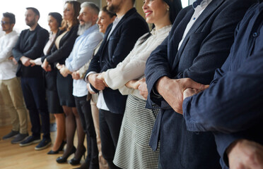 Closeup of employees stand in line hold hands make chain show unity and leadership. Diverse...