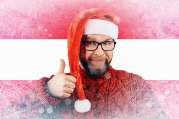 Portrait of cute handsome attractive cheerful bearded Santa shows thumbs up on background of frozen Austrian flag, toned