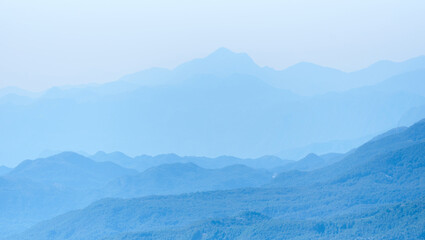 Obraz premium Mountain range silhouette in a blue haze